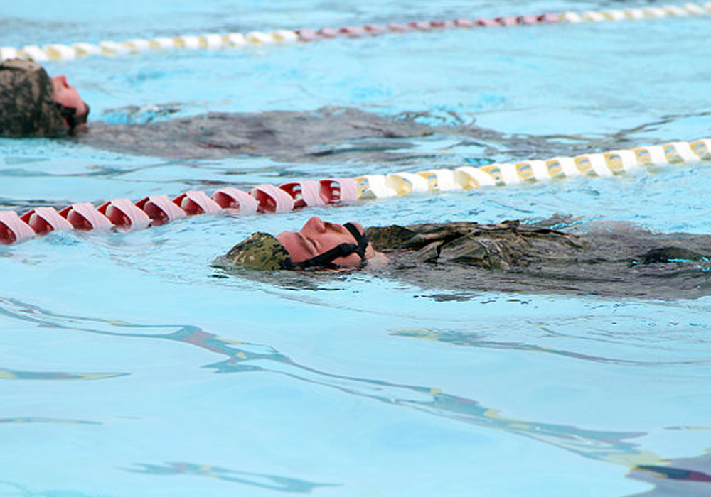 a member the Maritime Security Detachment at Joint Task Force Guantanamo uses swim back glide during his water survival training